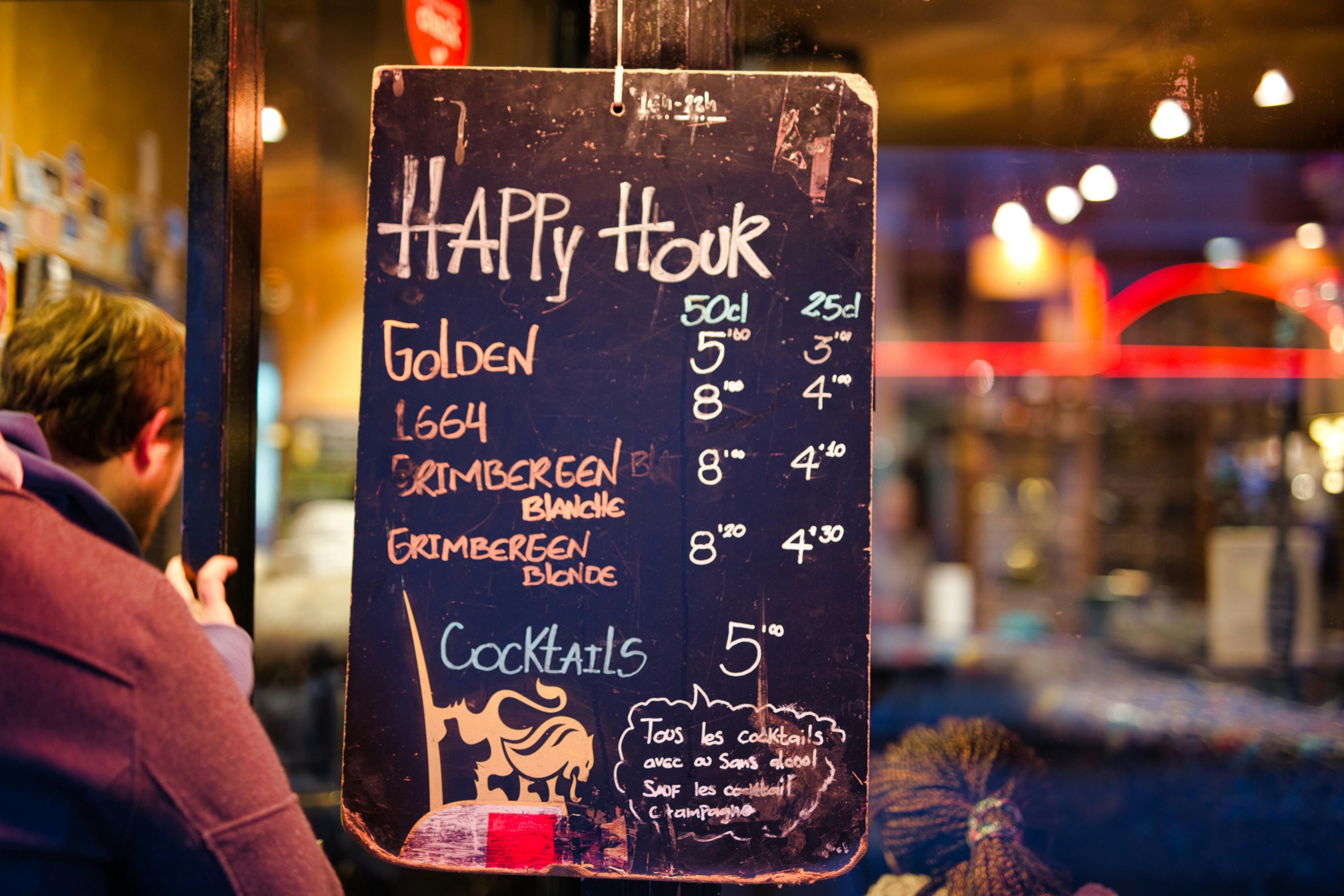 Pizarra de happy hour en la entrada de un bar