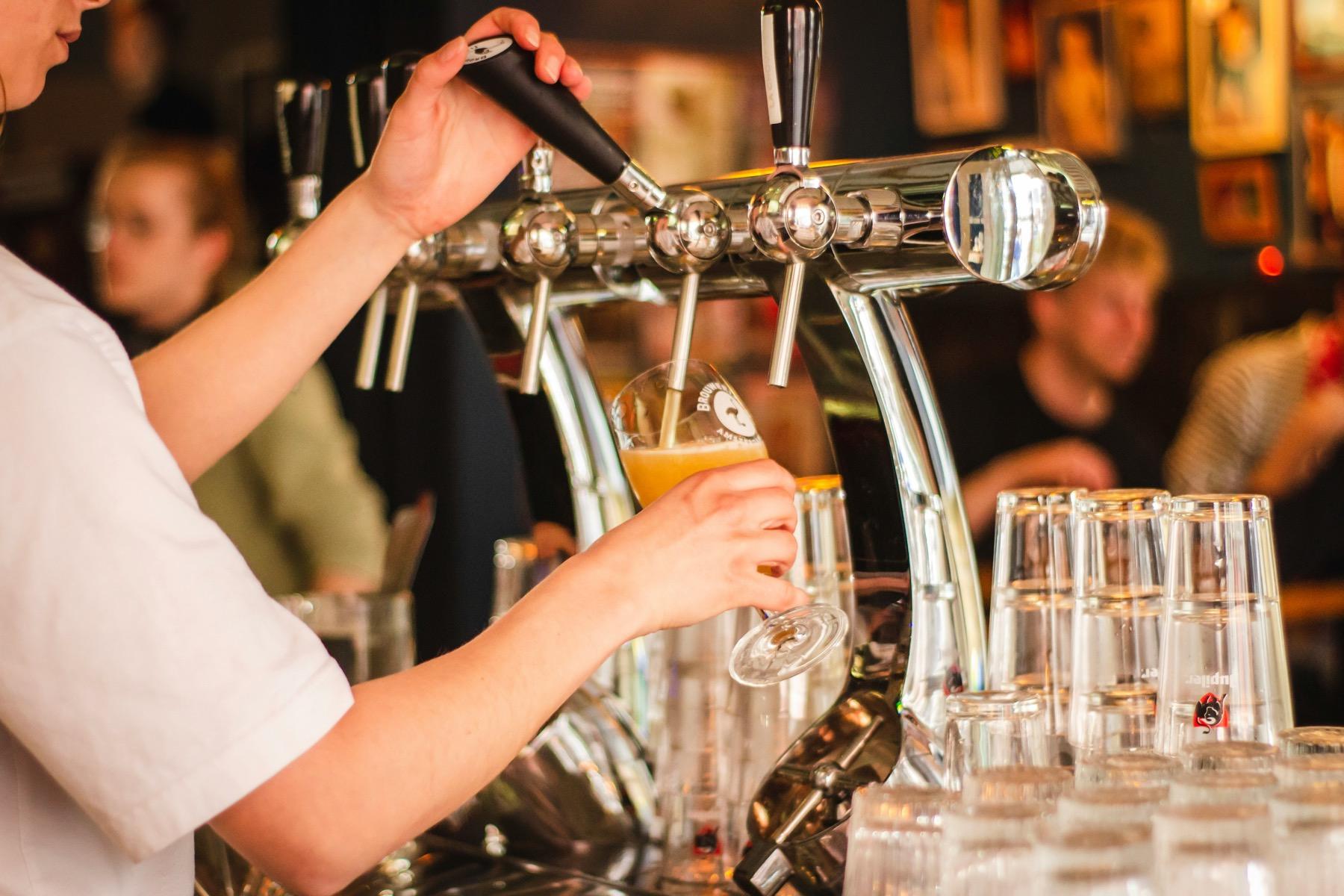 Ambiente real de un bar con el camarero sirviendo una cerveza
